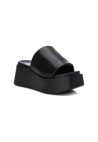 Sandalias de plataforma negras con una parte superior de cuero suave y una suela gruesa de goma moldeada que ofrece altura y comodidad adicionales.