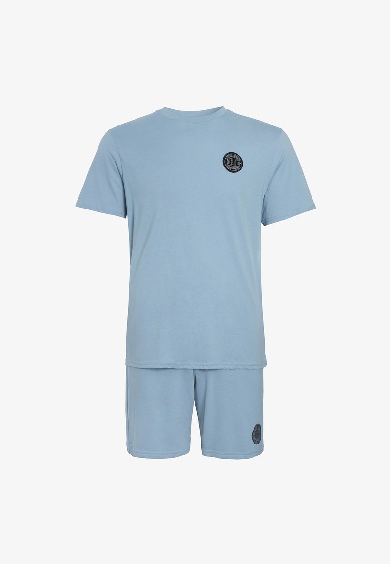 Világoskék pamut póló és rövidnadrág szett. A póló rövid ujjú és kerek nyakú, az elején egy fekete kör alakú logóval.