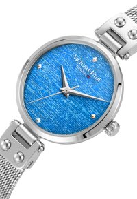 Reloj de metal plateado con una esfera texturizada azul, que presenta agujas de hora y minuto plateadas, cuatro marcadores de hora plateados y una correa de malla.