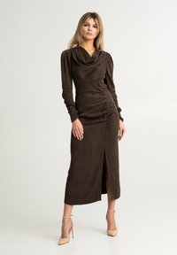 Braunes langärmliges Kleid mit Schalkragen und Raffung an der Seite, ausgestattet mit einem Oberschenkelspalt und weichem, strukturiertem Stoff.