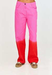 Spodnie w różowo-czerwonym ombre z rozszerzanym fasonem, wykonane z bawełnianej tkaniny. Posiadają przednie kieszenie oraz kontrastowe szwy.