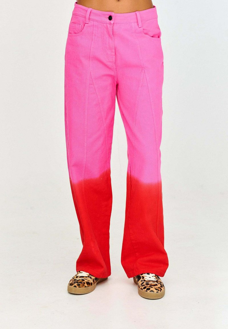 Spodnie w różowo-czerwonym ombre z rozszerzanym fasonem, wykonane z bawełnianej tkaniny. Posiadają przednie kieszenie oraz kontrastowe szwy.