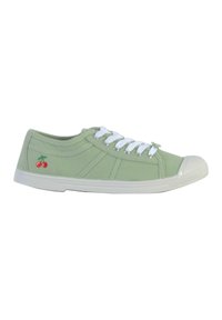 Sneaker di tela verde chiaro con punta in gomma bianca, lacci bianchi e ciliegie rosse ricamate sul lato esterno. Suola piatta, design casual.