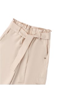 Jasnobeżowe spodnie o miękkiej teksturze, z elastycznym paskiem w talii i związanym paskiem. Posiadają boczne kieszenie oraz dekoracyjny emblemat serca na kieszeni.