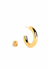 Pendiente de aro dorado con un acabado liso y brillante, que presenta un diseño curvado. Acompaña un pieza cilíndrica más pequeña, también en dorado.