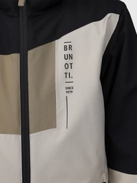Giacca frontale con logo verticale "BRUNOTTI" e testo "Dal 1979" su un tessuto beige e nero a blocchi di colore, con zip centrale.
