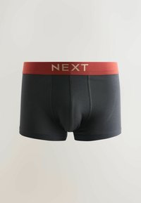 Boxers pour hommes noirs avec une ceinture rouge portant le nom de la marque "NEXT" en lettres dorées, présentés sur un fond neutre.