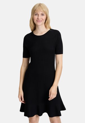 Robe noire à manches courtes, décolleté rond et ourlet évasé avec des vagues. Fabriquée dans un tissu lisse et extensible. Design simple et ajusté.