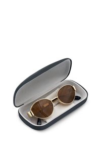 Okulary przeciwsłoneczne w złotej oprawie z brązowymi soczewkami, umieszczone w czarnym twardym etui z szarym wnętrzem. Etui ma zaokrąglone krawędzie.