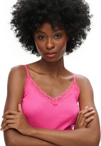 Camiseta de tirantes rosa con canalé y con un borde de encaje en el escote, presenta un diseño ajustado y una textura suave.