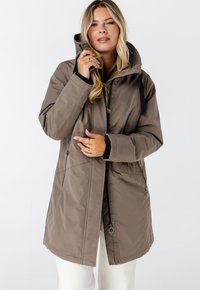 Bruine waterdichte parka met capuchon, voorzien van een ritssluiting, zijzakken en verstelbare trekkoorden. Gemaakt van een gladde, duurzame stof.