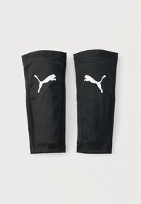 Μαύροι αθλητικοί επιγονατίδες από λείο ύφασμα, με λευκό λογότυπο Puma σε κάθε κομμάτι. Σχεδιασμένοι για εφαρμογή και προστασία κατά τη διάρκεια αθλημάτων.