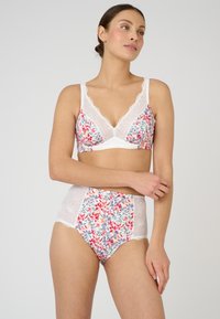 Conjunto de lencería floral que incluye un bralette de encaje blanco con cuello en V y braguitas de talle alto con un patrón floral en tonos rojos y azules.