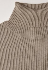 Beige gerippter Rollkragensweater mit hohem Kragen, der eine feine Stricktextur und vertikale Streifen aufweist.