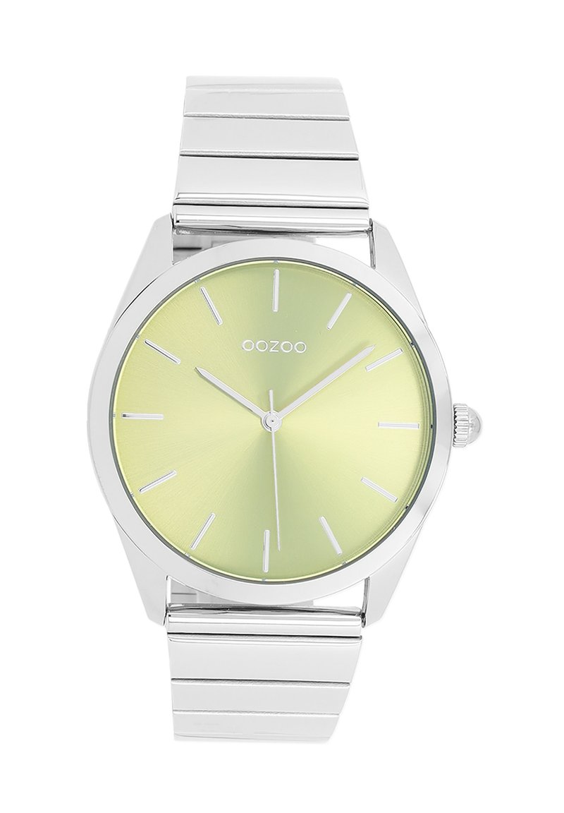 Montre en métal argenté avec un cadran rond vert clair. Dispose d'index horaires en bâton et d'une lunette lisse. Bracelet à maillons intégrés.