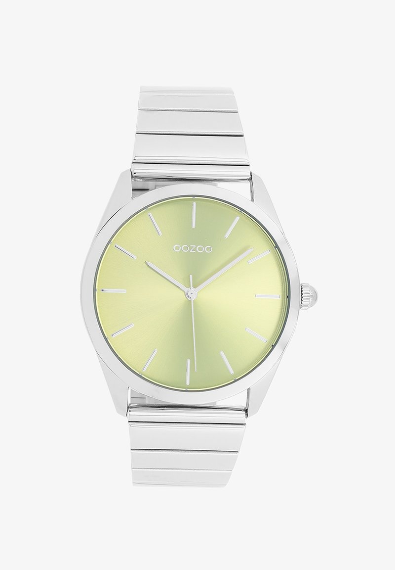 Montre en métal argenté avec un cadran rond vert clair. Dispose d'index horaires en bâton et d'une lunette lisse. Bracelet à maillons intégrés.