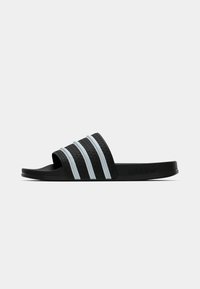 Sandale blanche noire avec trois bandes blanches sur la bride, dessus texturé et semelle lisse. Présente le logo Adidas sur le côté.