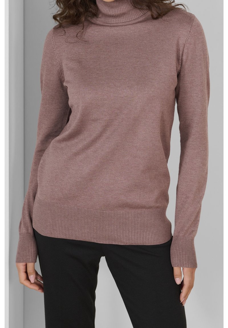 Pullovertrui in zacht mauve breiwerk, voorzien van een opstaande kraag, geribde boorden en zoom. Gecombineerd met zwarte broeken voor een casual look.