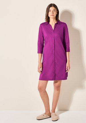Robe boutonnée violette avec des manches trois-quarts et une coupe droite. Tissu doux, texture lisse et un design de col simple.