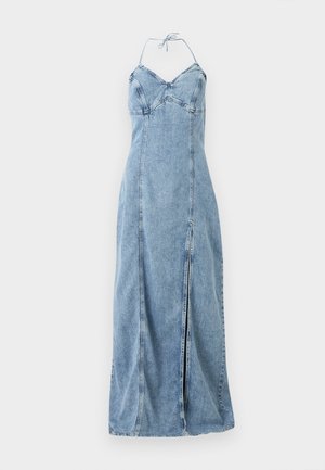 Gaiši zilas džinsa halterveida maxi kleita ar pieguļošu augumu un priekšējo šķēlumu uz vienveidīga fona.