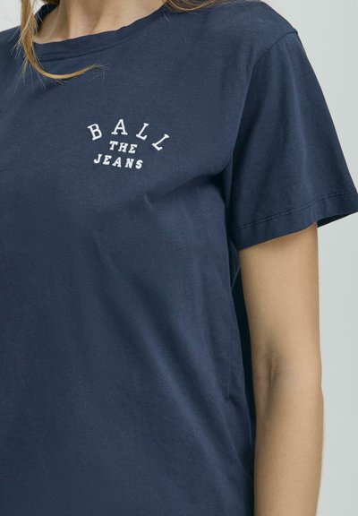 Námořnická modrá bavlněná tričko s krátkými rukávy a kulatým výstřihem, zdobené bílým vyšívaným textem "BALL THE JEANS."