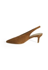 Escarpin à talon modéré en daim marron avec un bout pointu. La chaussure présente un design découpé sur les côtés pour une allure élégante.