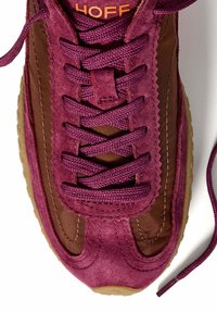 Zapatilla de ante morado con acentos de tela marrón, que presenta costuras delineadas, cordones planos y una suela de goma texturizada. Nombre de la marca "HOFF" visible.