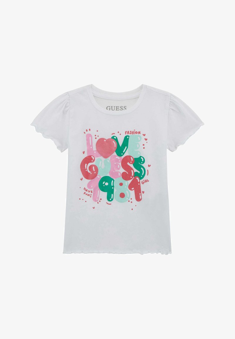 Valkoinen puuvillapaita, jossa on värikäs graafinen tekstimuotoilu, sydämiä ja leikkisää typografiaa. Puffihihat ja aaltoileva helma.