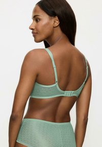 Miętowy stanik z wzorzystą koronką, regulowanymi ramiączkami oraz zapięciem na haftkę z tyłu, w zestawie z dopasowanymi majtkami.