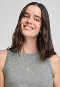 Graues Baumwoll-Tanktop mit rundem Ausschnitt. Verfügt über ein weißes Logo auf der Brust und ein ärmelloses Design, das eine weiche Textur zeigt.