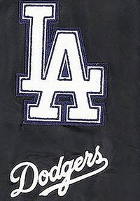 Zwarte stof met een groot wit geborduurd "LA" logo omrand met blauw, en het woord "Dodgers" in cursieve witte letters eronder.
