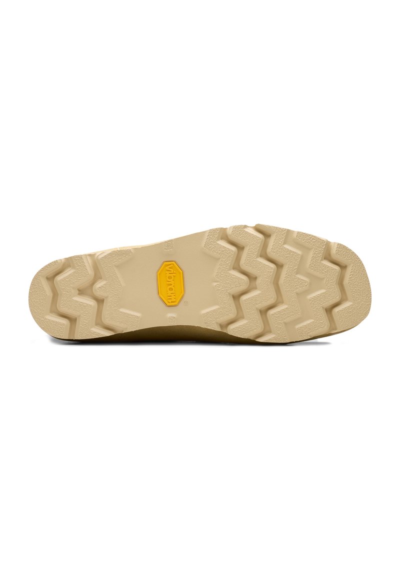 Brown rubber shoe sole with a textured zigzag pattern. Features yellow logo, sturdy design, and a light beige color.