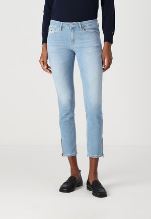 Jeans recortados de color azul claro en denim desgastado con un corte ajustado, cremalleras laterales en el dobladillo y un diseño clásico de cinco bolsillos.
