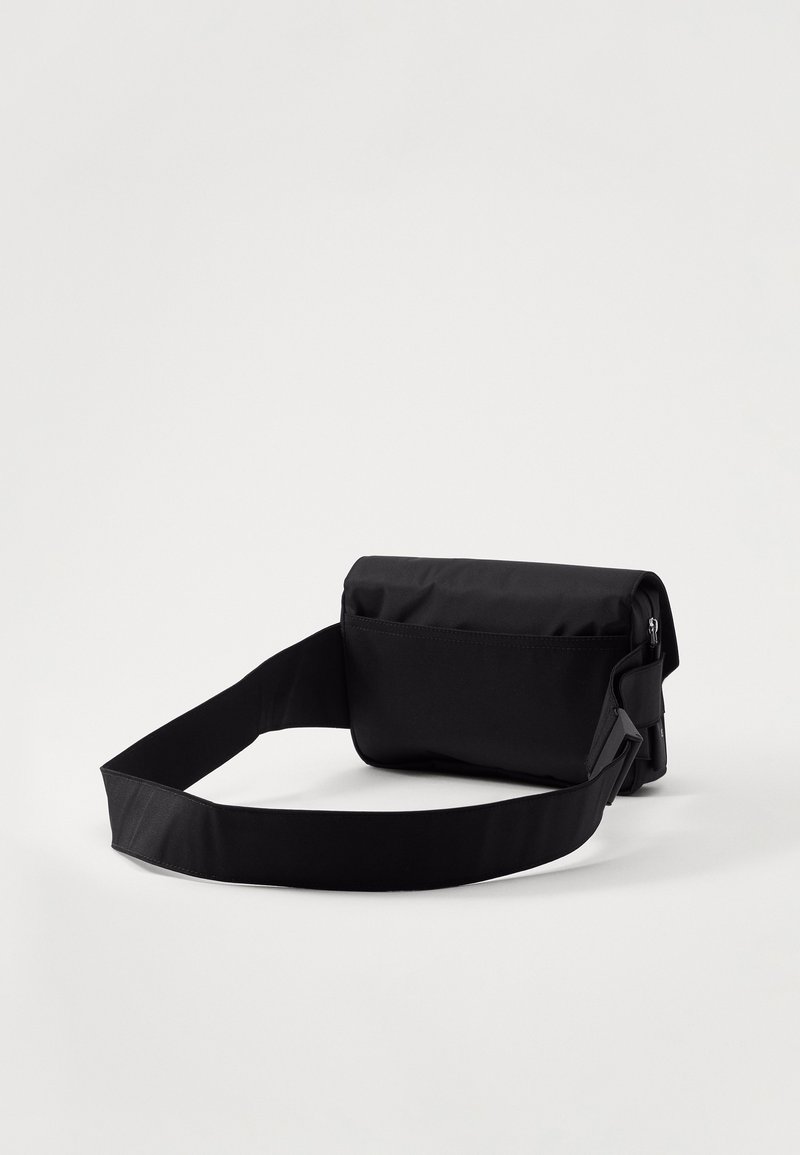 Borsa a tracolla nera e rettangolare realizzata in tessuto resistente. Caratterizzata da una tracolla staccabile e regolabile e da una chiusura a patta con tasca con zip.