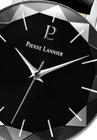 Melna pulksteņa saskare ar sudrabainiem akcentiem, izteiksmīgi stundu rādītāji un zīmola logo "Pierre Lannier." Iezīmē teksturētu virsmu un facētu rāmīti.