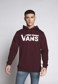 Bordový mikina s veľkým bielym logom "VANS", kapucňa so šnúrkou a klokanie vrecko; vyrobená z mäkkého, štruktúrovaného textilu.