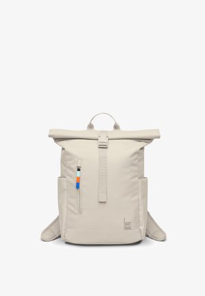 Sac à dos beige à rabat avec poche zippée à l'avant, tirette de fermeture éclair colorée, poches latérales, poignée supérieure et bretelles, marqué "GOT BAG".