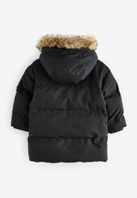Svart puffjacka med huva och fuskpälsdetaljer, med en quiltad design, elastiska manschetter och en avslappnad passform. Bakåtsikt visas.