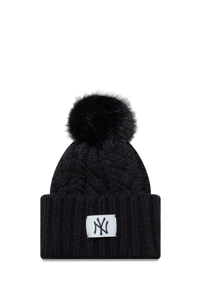 Musta neulepipo, jossa on palmikkokuosi, ja jossa on keinotekoista turkista oleva pom-pom sekä valkoinen logopatchi edessä.