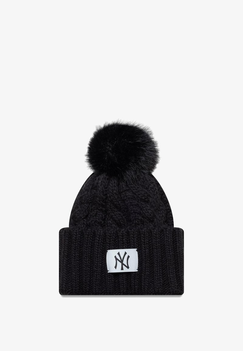 Musta neulepipo, jossa on palmikkokuosi, ja jossa on keinotekoista turkista oleva pom-pom sekä valkoinen logopatchi edessä.