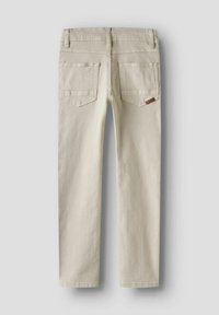 Beige denimbukser med rett ben-design, som har to baklommer og en tan skinnlapp. Glatt tekstur og minimale sømdetaljer.