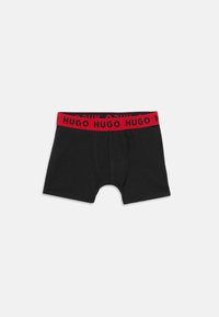 Čierne boxerky vyrobené z bavlny, so zeleným elastickým pásom s opakujúcim sa textom "HUGO". Navrhnuté s priliehavým strihom a šitými detailmi.