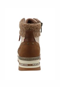 Stivale mid-top in suede marrone con un collare soffice color tan, dotato di inserti in metallo, cerniera laterale e suola in gomma con il marchio "MUSTANG".