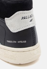 Must beez ja must nahk ja samet kõrged tennisetaild, valge kummitald; omadused embosseeritud brändimise ja mudeli numbri seljatallal.