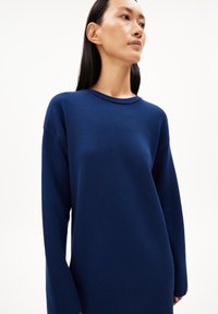 Maglione oversize blu navy realizzato in tessuto testurizzato, con scollatura rotonda e maniche lunghe. Design semplice e minimal senza motivi.