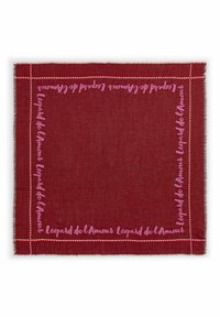 Écharpe rouge rectangulaire avec le texte rose "Léopard de l’Amour" le long de la bordure et un petit motif triangulaire sur les bords.