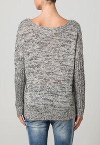 Maglione grigio e bianco a maglia con una vestibilità rilassata, scollo a barca e maniche a coste. Motivo testurizzato con un aspetto morbido.