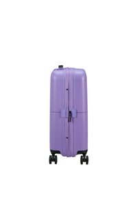 Valigia rigida di colore viola chiaro, caratterizzata da una superficie liscia, doppia cerniera e quattro ruote nere per la massima mobilità.