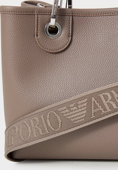 Brown textured synthetic handbag featuring metal hardware and a prominent strap with "Emporio" text woven on it.