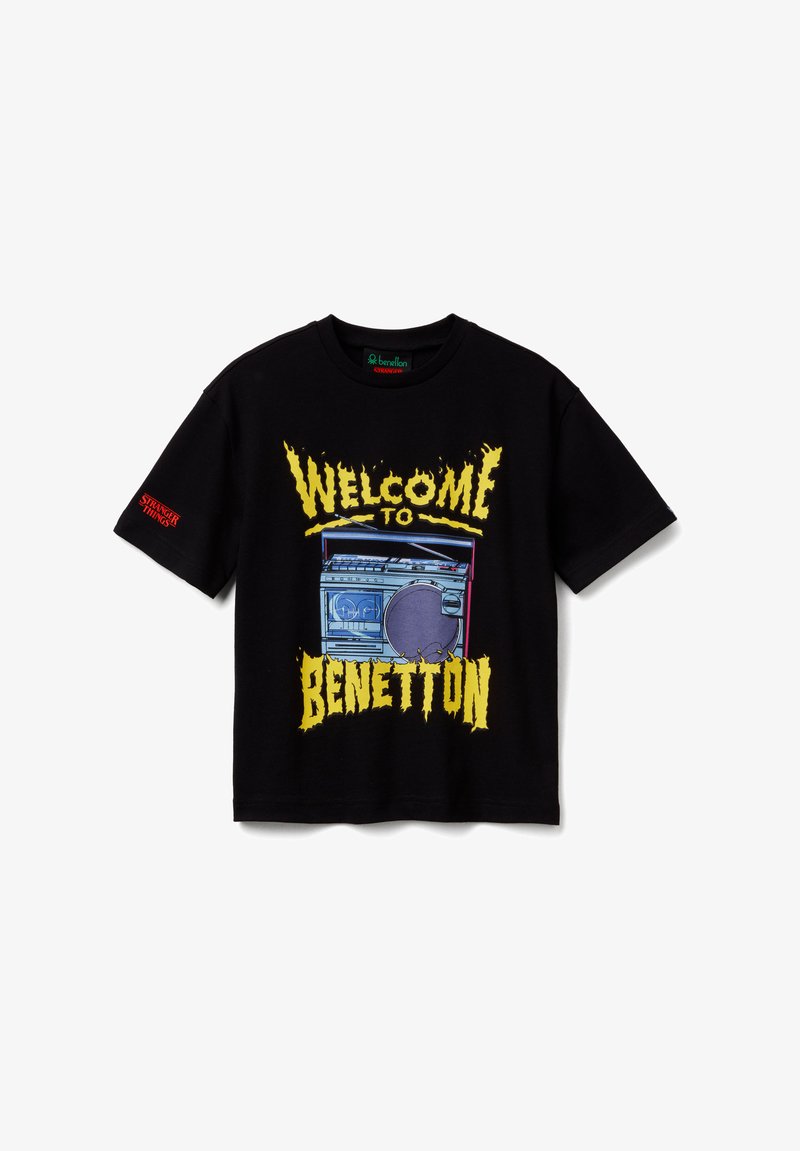 T-shirt noir à manches courtes avec texte jaune "Welcome to Benetton" et un graphisme d'un boombox bleu et violet sur le devant, texte "Stranger Things" sur la manche.